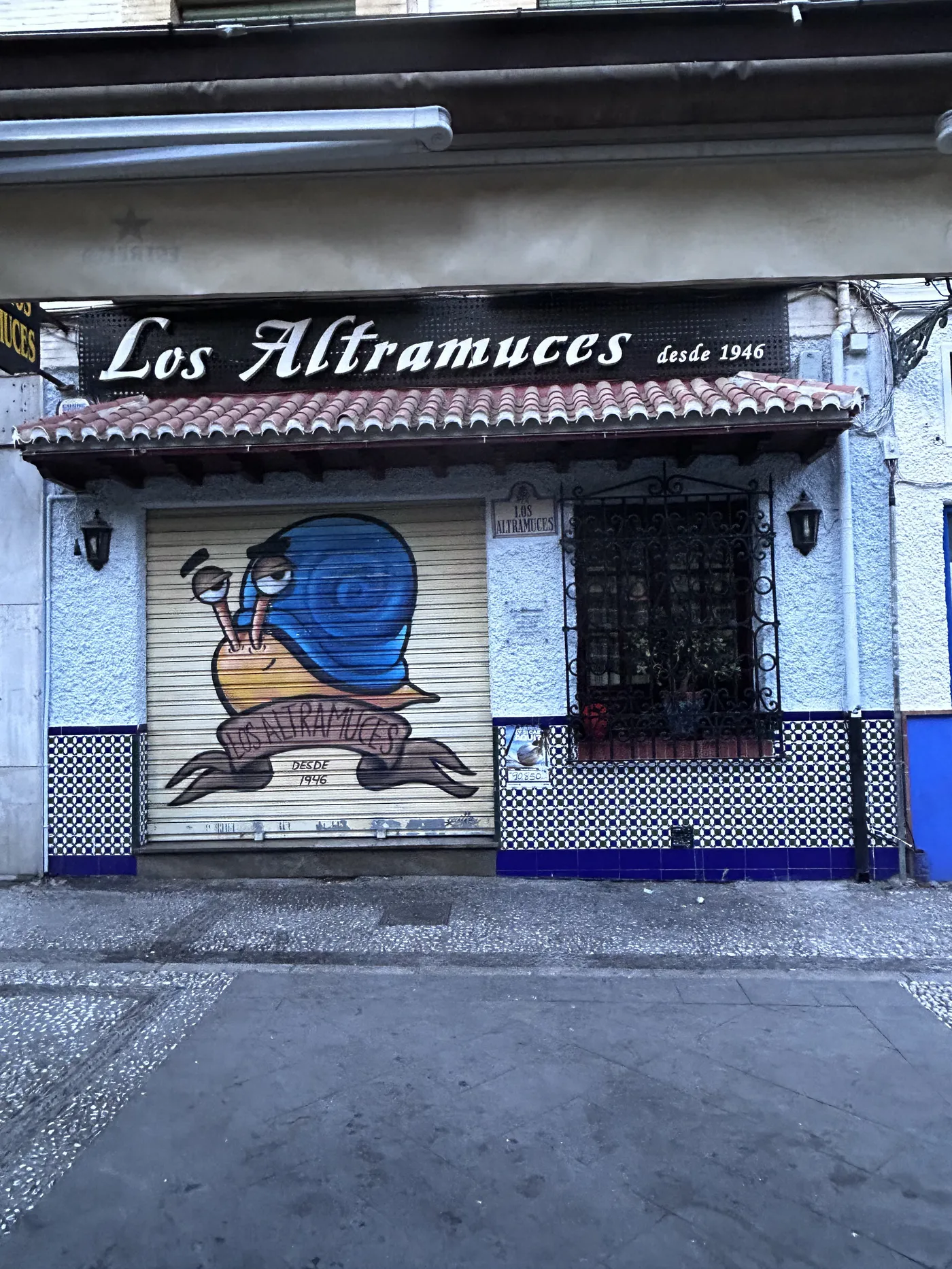 Fachada de un bar histórico de tapas de Granada con el cierre pintado