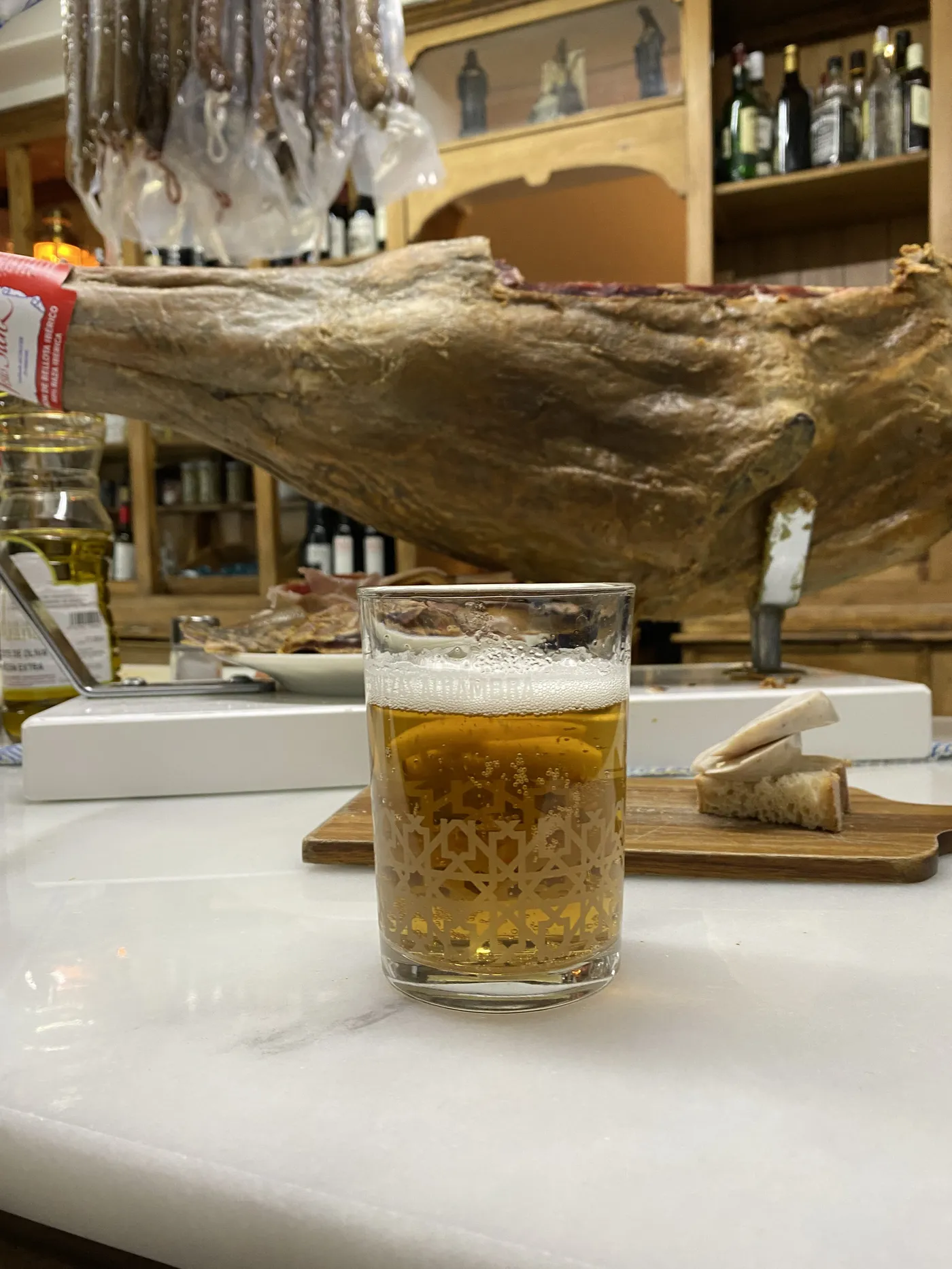 Jamón cortado a mano y una caña en una barra clásica de Granada