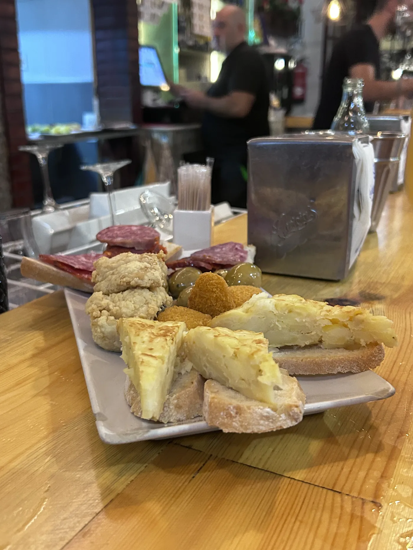 Tapas variadas recién servidas en una barra de Granada